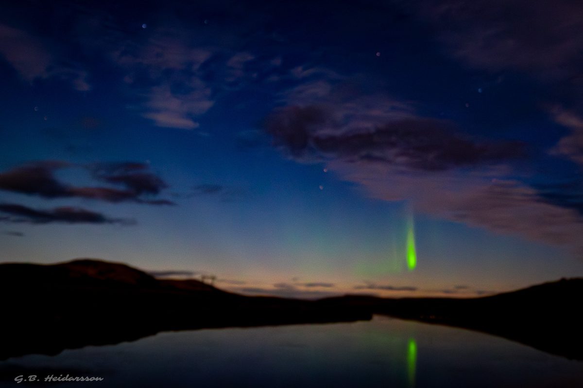 Aurora at blue hour over still water